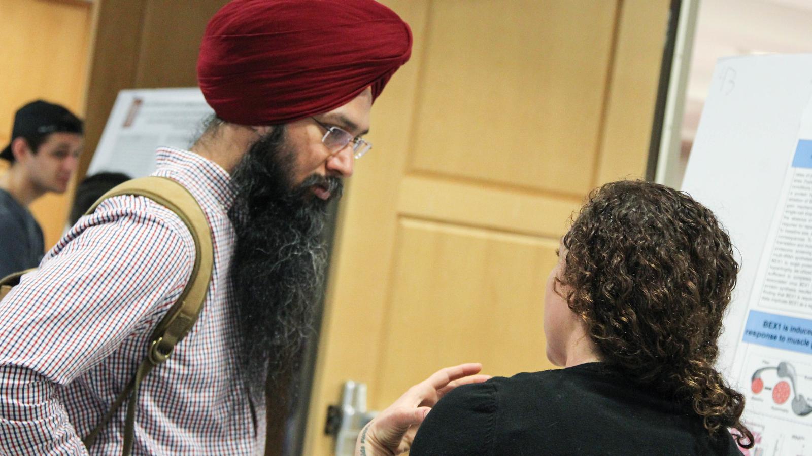 Two people discuss research during a poster session